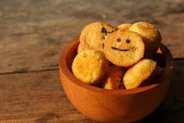 Kue bolu kering or Dried sponge cake in a small wooden bowl with wooden background