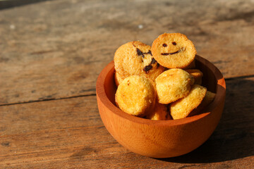 Kue bolu kering or Dried sponge cake in a small wooden bowl with wooden background