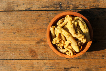 Fried chicken intestines Indonesian food is called usus goreng in a small wooden bowl with wooden background