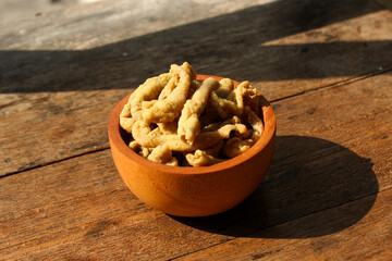 Fried chicken intestines Indonesian food is called usus goreng in a small wooden bowl with wooden background
