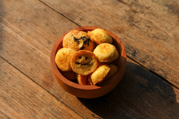 Kue bolu kering or Dried sponge cake in a small wooden bowl with wooden background
