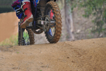 Naklejka premium Close-up of motocross wheel, acceleration with mountain bikes in dirt track, blurry background and motion blur