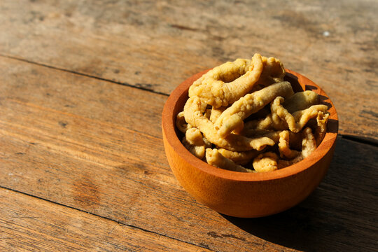 Fried chicken intestines Indonesian food is called usus goreng in a small wooden bowl with wooden background