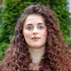 Close-up portrait of a brunette woman with long curly hair.