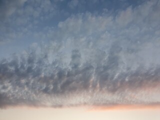 Texture of white clouds against a sunset background.