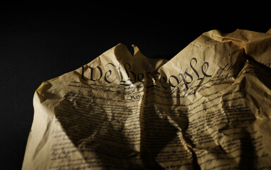 Wrinkled and crumpled US Constitution on dark background