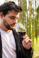 Hombre apuesto degustando una copa de vino