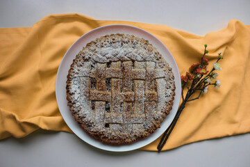 homemade cherry pie horizontal top view, yellow background with flowers