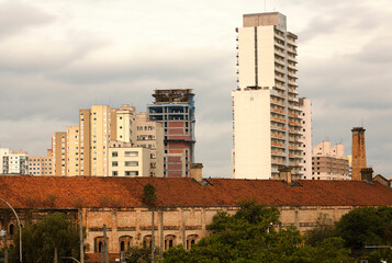 Prédios, viadutos, casas, guindaste, árvores e as cores da cidade de São Paulo.