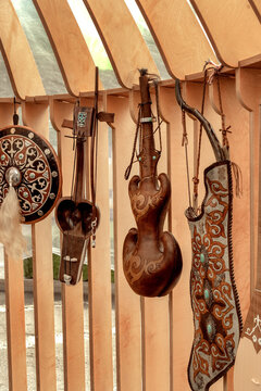 Traditional Kazakh leather flask for drinks, a quiver with a bow and arrows, a musical instrument - kobyz and a warrior's shield on the wall of a street store