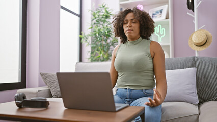 African american woman meditating indoors on a sofa