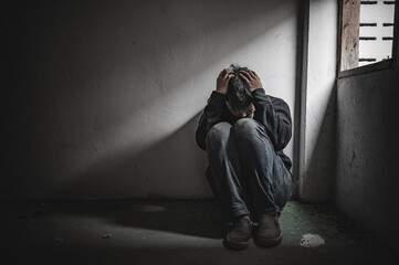 Asian man addict drug in the deserted place,A junkie feels alone in this world,Sad young man sitting in the corner of the room,People are stressed and have depression