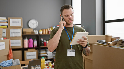 Handsome man with beard talking on phone and holding notebook in warehouse