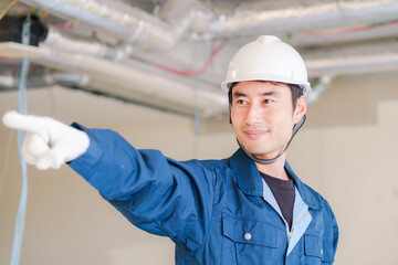 指差しをして安全確認をする男性の建築作業員