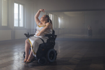 Smiling young woman with a disability, a wheelchair dancer enjoying performing graceful dance moves. Sport and wellbeing concept.