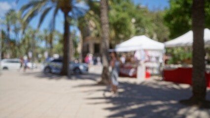Obraz premium Blurred scene of an outdoor market in mallorca showcasing blurred palm trees, a woman, street vendors, defocused people, vibrant market stalls, and a sunlit plaza.