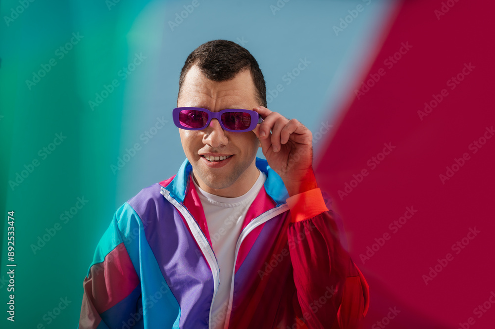 Wall mural happy smiling man wearing trendy purple color sunglasses, 80s style sport jacket. close up studio po