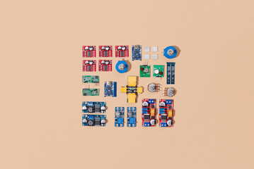 Microcontrollers, boards, sensors, leds and modules for learning the basics of electronics. Various electronic components for soldering arranged in creative arrangement