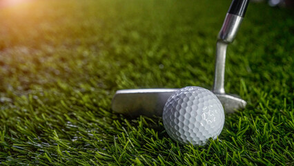 Golf clubs and balls on a green lawn in a beautiful golf course with morning sunshine.