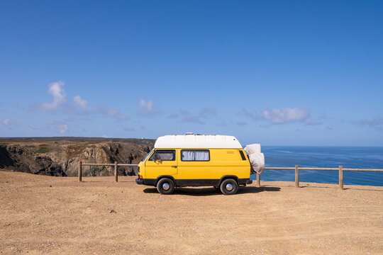 Retro camper van parked on the cliffs on Cordoama beach in Portugal