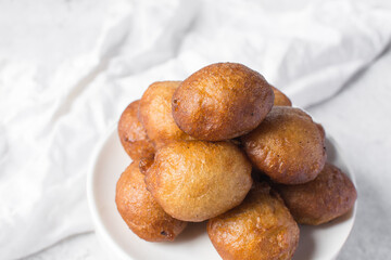 nigerian puff-puff on a white plate, nigerian fried dough balls, homemade bofrot on white dish