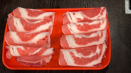 Sliced ​​pork on a red tray for a restaurant