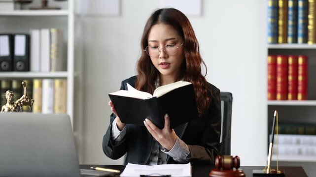 Female lawyer reading a law book in the lawyer's office.