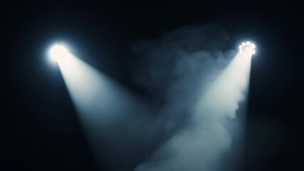 Spotlights illuminating smoke on dark stage