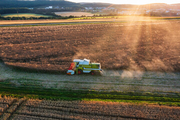 Bird's eye view of a grain field being harvested with a combine harvester