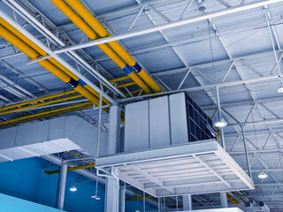 Ceiling with ventilation pipes and lights in industrial building