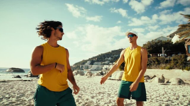 Dynamic handheld shot of professional sportsmen displaying teamwork on beach volleyball court