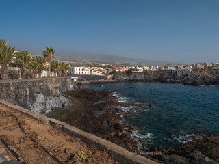 Fototapeta premium Views of the picturesque Alcala village with traditional architecture houses, small tranquil cove with beach and pier crowded with sunbathing people. Tenerife, Canary Islands, Spain.