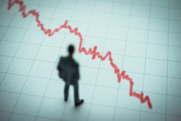 Businessman looking at falling down red graph tensely. Economy recession crisis, sales are falling,...
