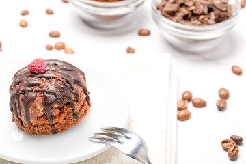 Round chocolate cakes. Decorated with candied raspberries. Light background.