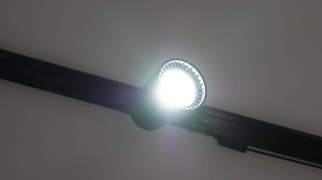 Spot track led lamp loft on the ceiling. Slide in slow motion. Electricity chandelier, modern black.