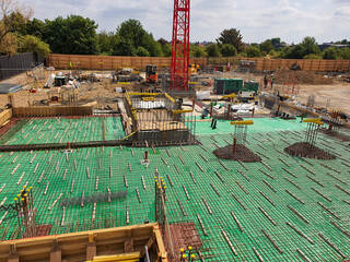 Gas membrane installation at a construction site with foundation work and equipment. Construction...