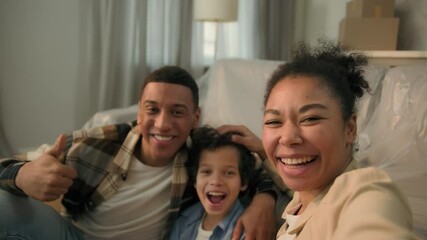 African American happy family parents son together grimacing selfie photo mobile phone camera having fun laugh joyful funny mom dad little child kid boy smartphone video call live blog moving day home