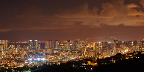 Cityscape, night and lights with city, buildings and popular tourist or vacation destination in Waikiki honolulu. Luxury travel, skyscrapers and scenic landscape with coast, sunset or holiday evening