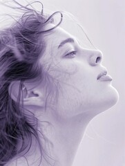 Fototapeta premium Profile of a Young Woman with Windswept Hair in Soft Purple Tones