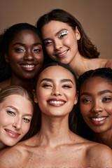 Fototapeta premium diversity and vertical portrait of women happy with makeup for cosmetic skincare isolated in studio brown background. Skin, aesthetic and young friends together for self care, dermatology and support 