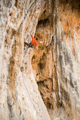 A rock climber climbs to the top along a difficult route.