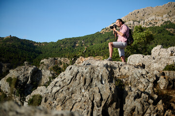 Man photographing beautiful mountainous landscape during a hike