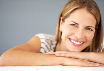 Fototapeta premium Relax, mockup or portrait of happy woman on sofa in living room to enjoy peace or break in home. Confident, satisfaction or female person in house lounge alone for resting, smile and lying on day off