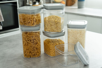 Plastic containers with various food types are on a table.On the table, there are several plastic containers containing various types of food