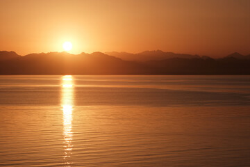 Rising sun over Saudi Arabia mountains and Gulf of Aqaba of Red Sea. View from Dahab, Egypt.