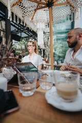 Startup team members having a business meeting discussing ideas and strategies while sitting in an outdoor cafe.