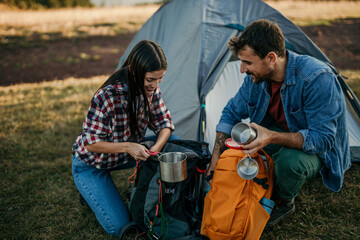 Young couple sitting at the top of the mountain over a fire