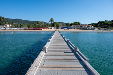 Obraz premium Morning view on crystal clear blue water of Plage du Debarquement white sandy beach near Cavalaire-sur-Mer and La Croix-Valmer, summer vacation on French Riviera, Var, France