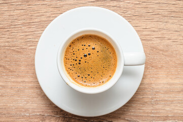 Cup of Turkish coffee on a weathered wooden table, top view,
