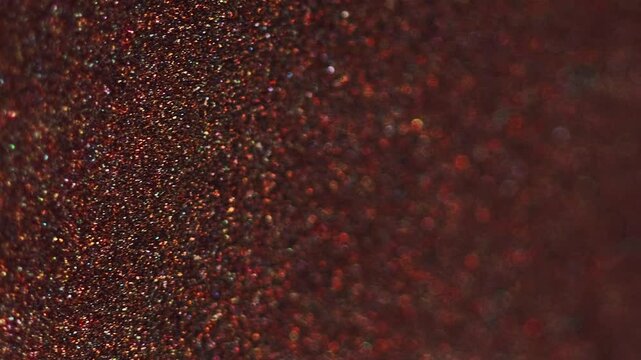 Shimmering texture. Glitter fluid wave. Blur red pink golden color shiny sparkling bokeh light grain paint flow decorative abstract art background.